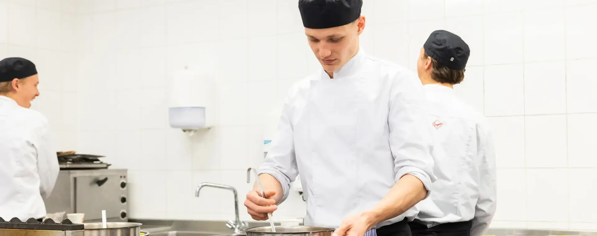 Kok werkt geconcentreerd aan een warm gerecht