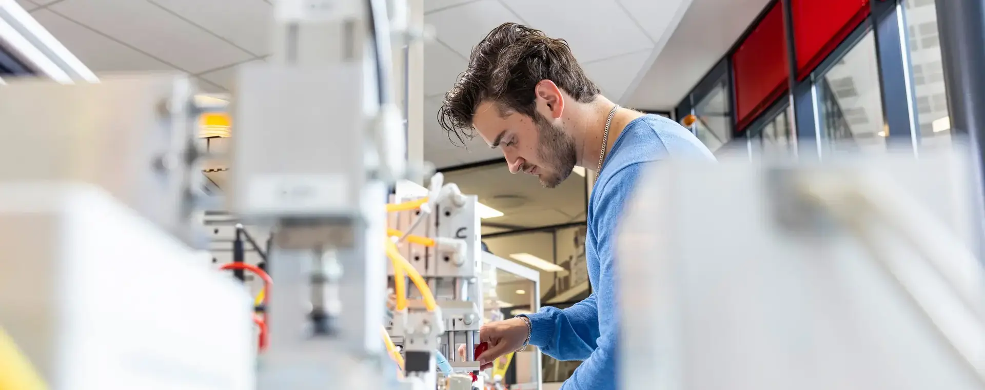 Jongeman sleutelt aan een technische installatie