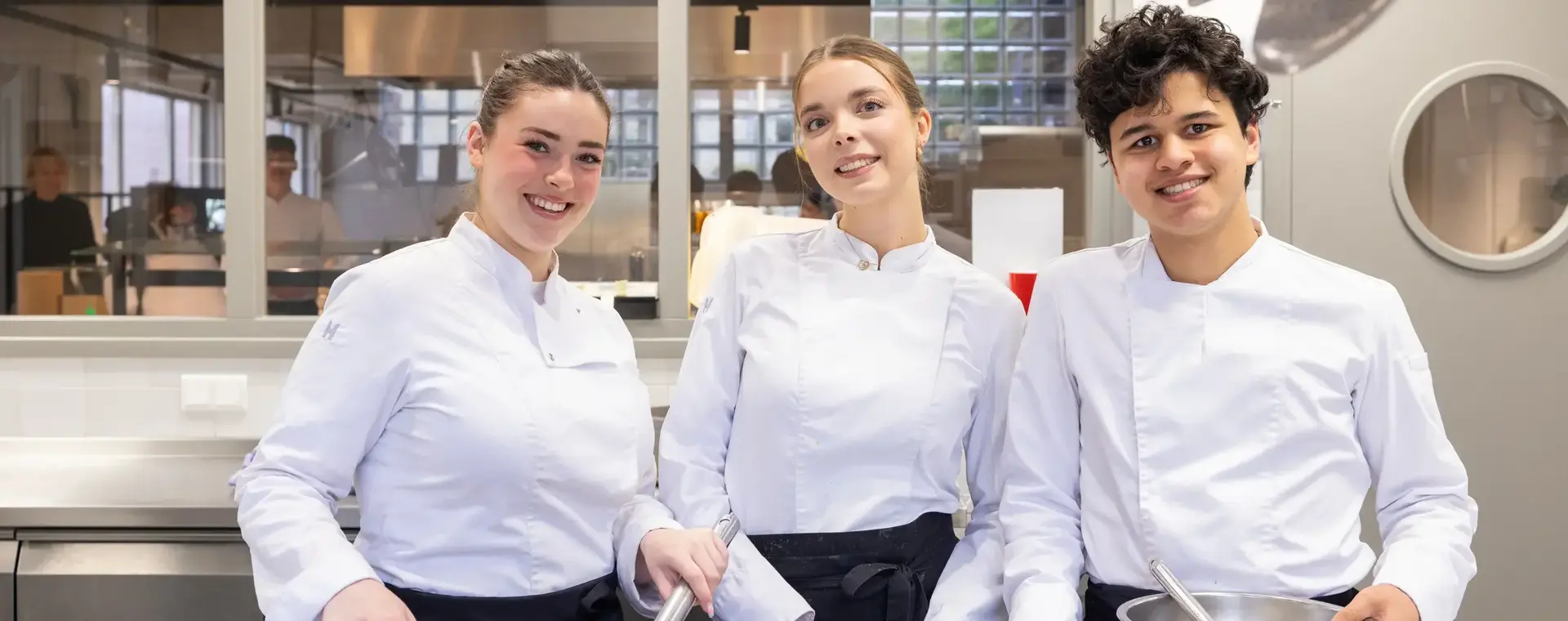Studenten koken met plezier samen tijdens een praktijkles