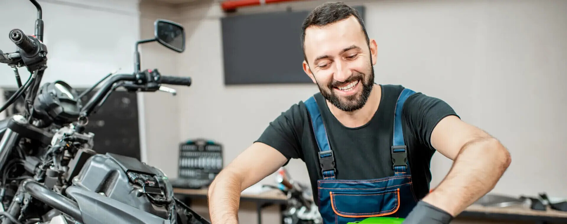 Monteur sleutelt vrolijk aan een motorfiets