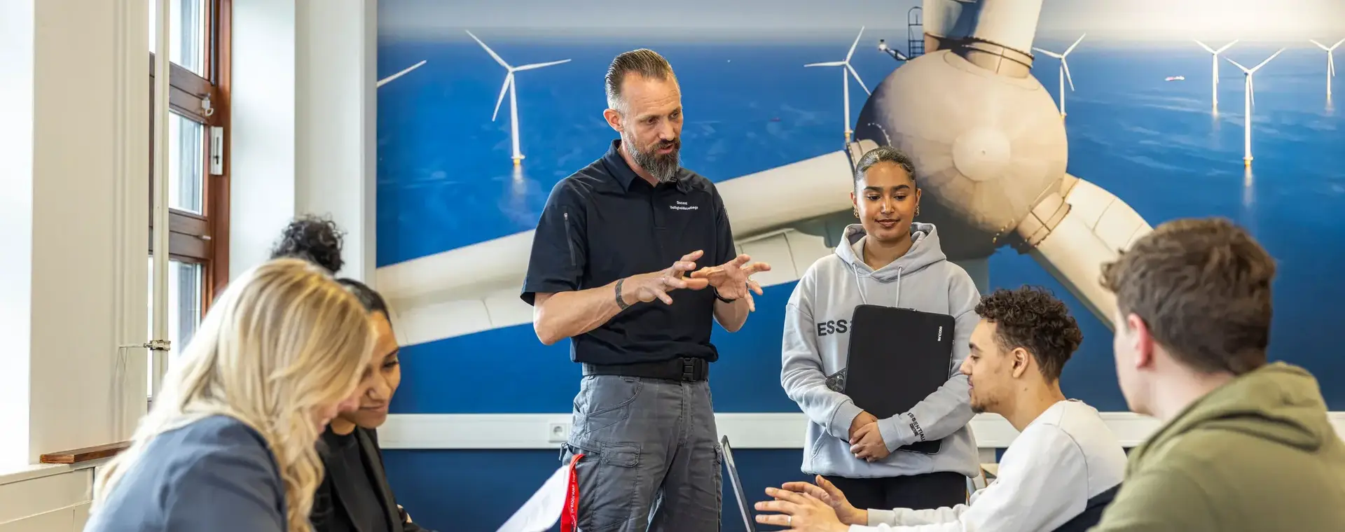 Docent legt werking windmolens uit aan studenten