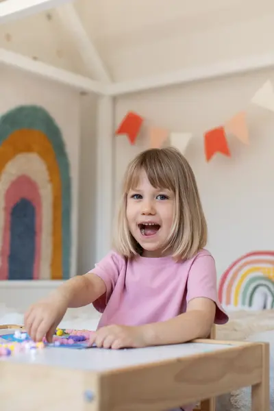 Lachend meisje in roze shirt in kinderopvang 