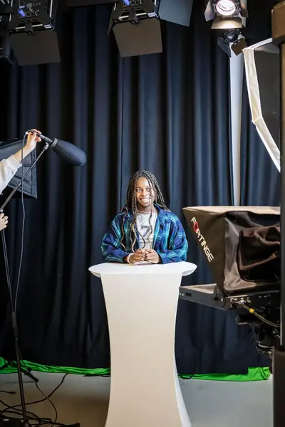 Presentatrice wordt opgenomen door een camera- en een geluidsvrouw .