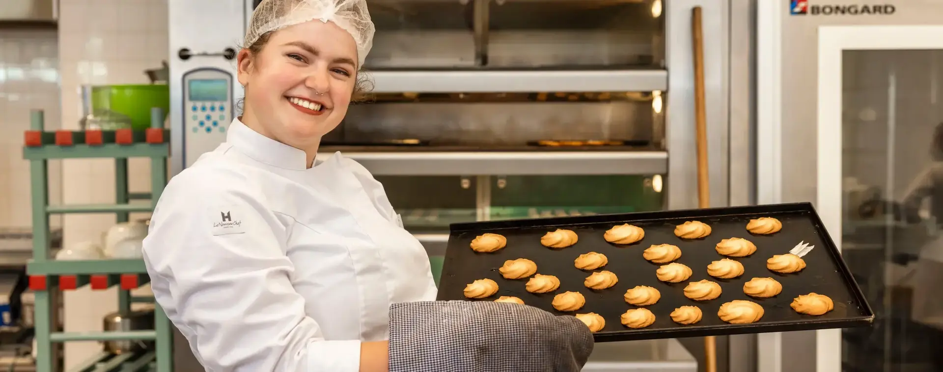 Bakker toont met trots een bakplaat vol verse koekjes