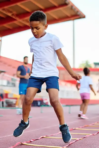 Kinderen zijn een spotoefening aan het doen op een atletiekbaan.