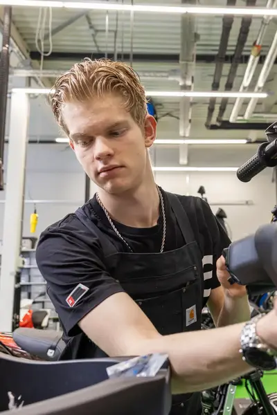 Student werkt aan scooter in werkplaats