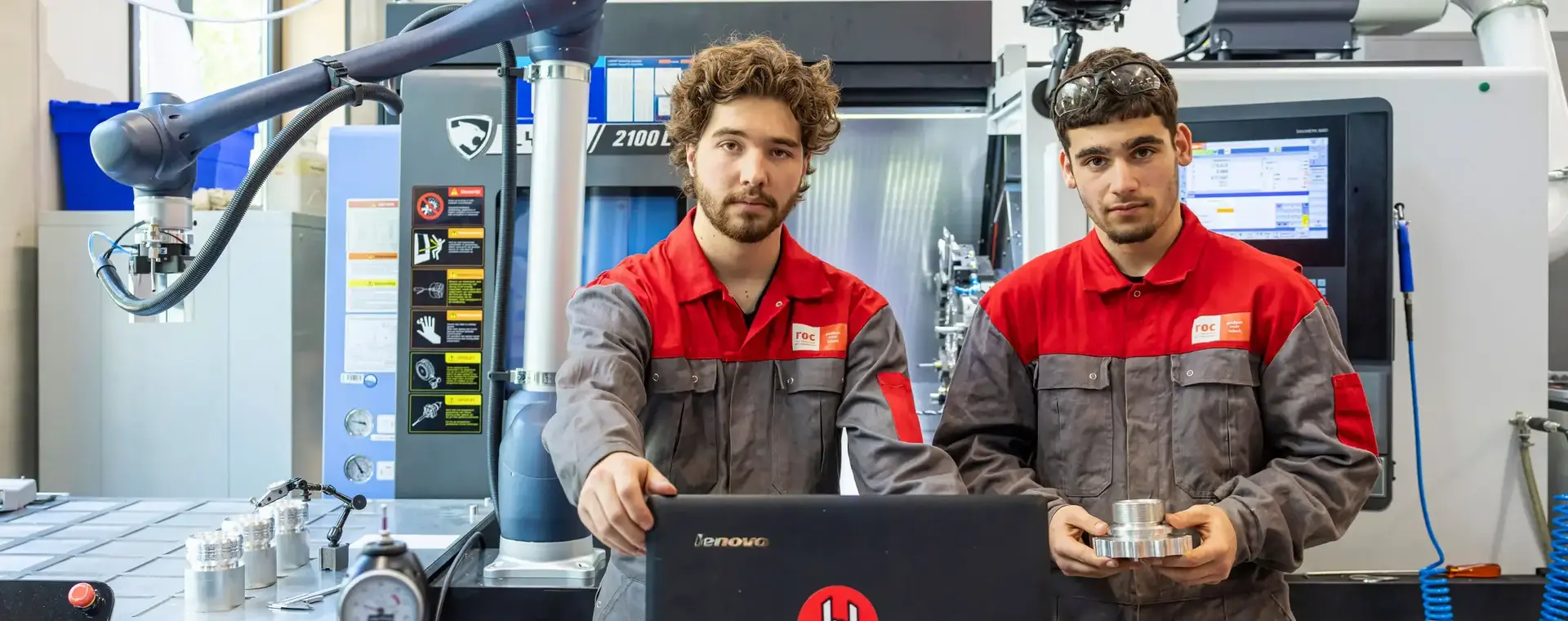 Twee studenten in een technische ruimte achter een laptop