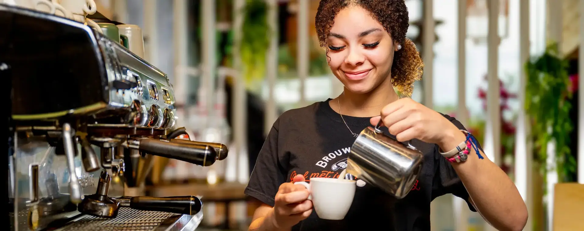 Student maakt een kop koffie in de horeca.