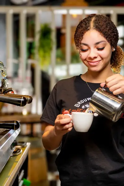 Student maakt een kop koffie in de horeca.