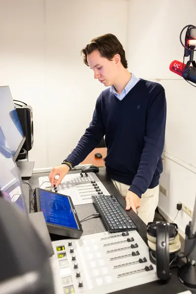 Student mengt het geluid op een mengpaneel.