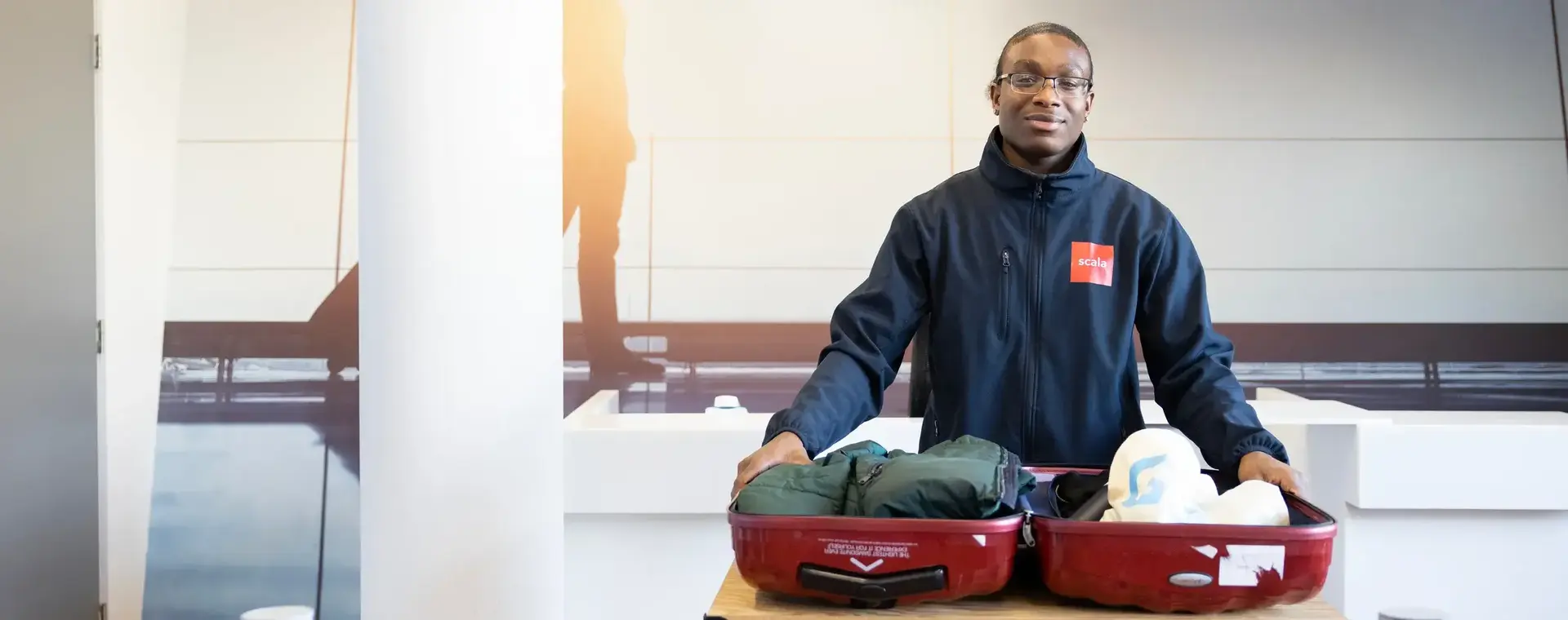 Student controleert een koffer op de luchthaven