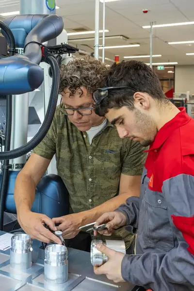 Student en docent werken aan metalen object