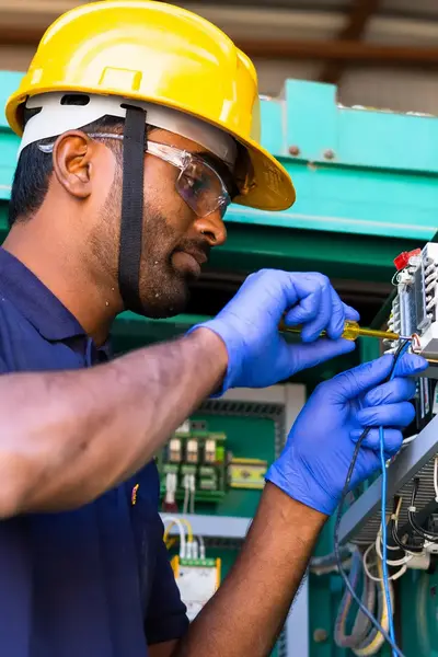 Met oog voor detail voert deze professional onderhoud uit aan een elektrische installatie.