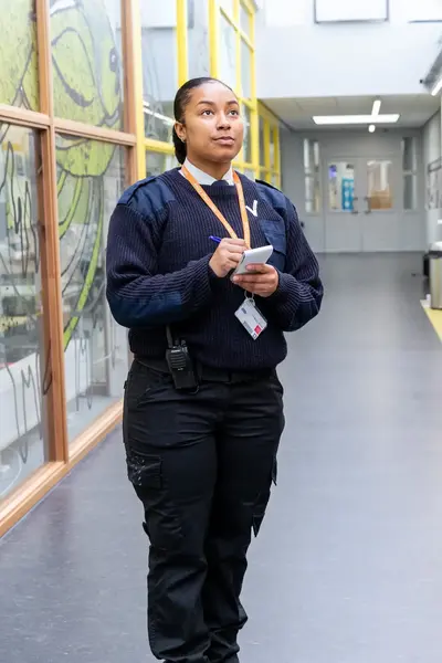 Student Veiligheidscollege in uniform maakt notities in gang