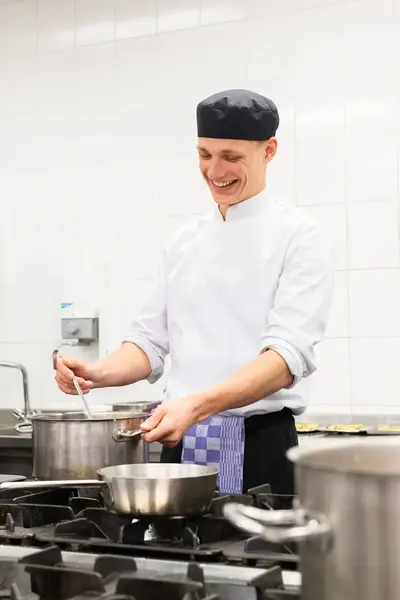 Kok bereidt maaltijd in grote keuken