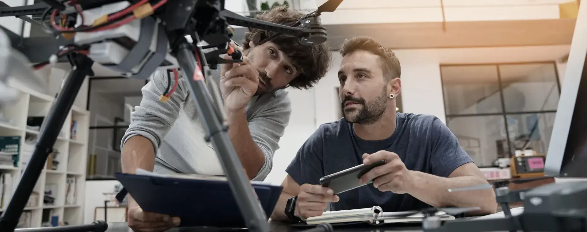 Student repareert drone met docent