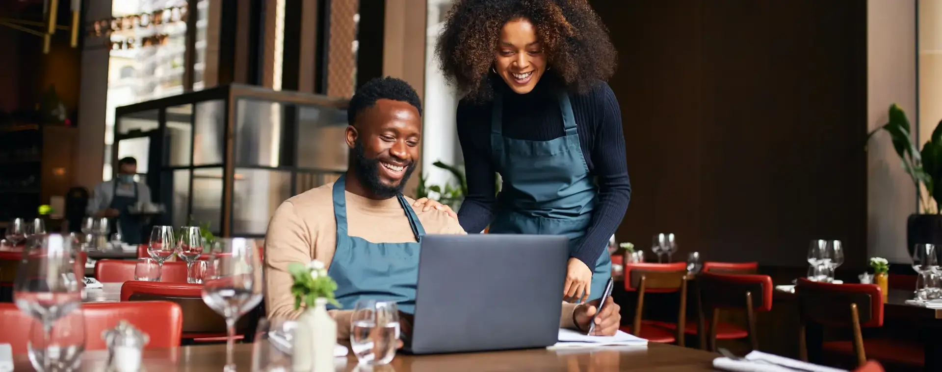 Twee collega's achter de laptop in een restaurant