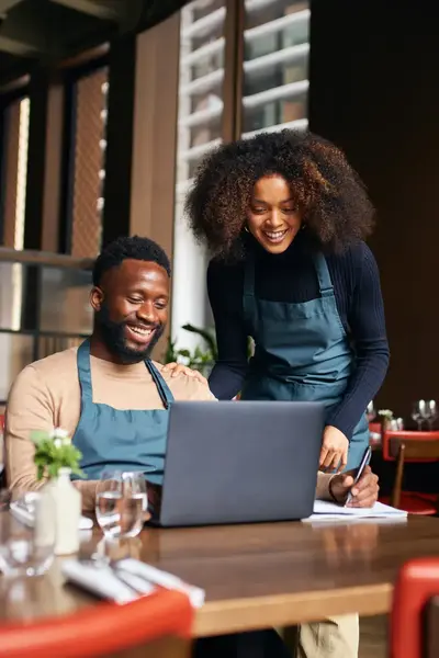 Twee collega's achter de laptop in een restaurant