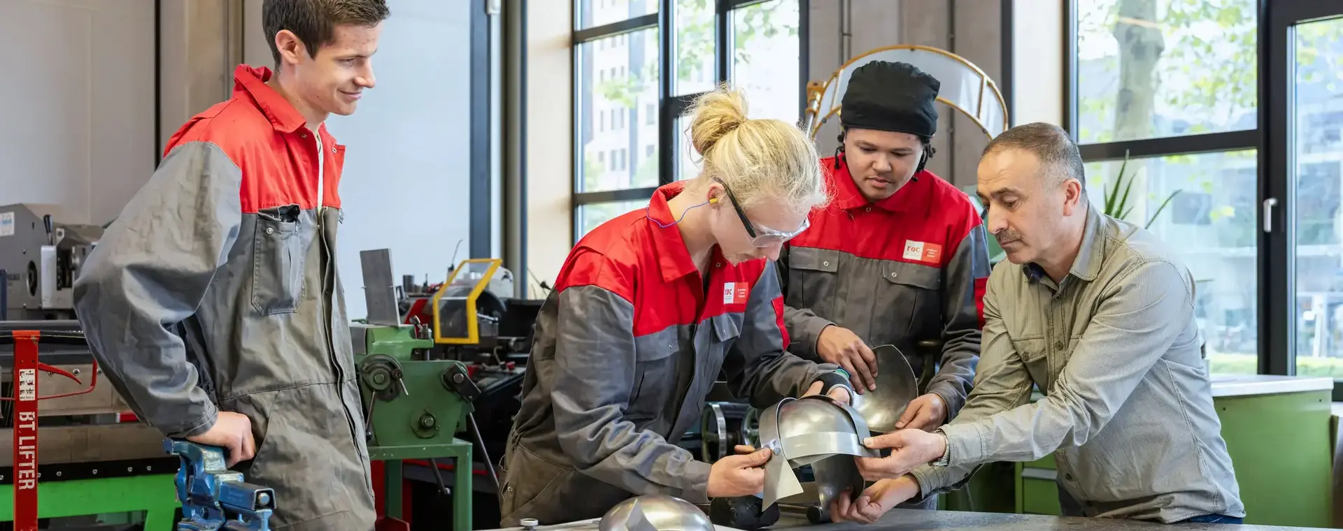 Groepje studenten in werkleding maken ridderhelm