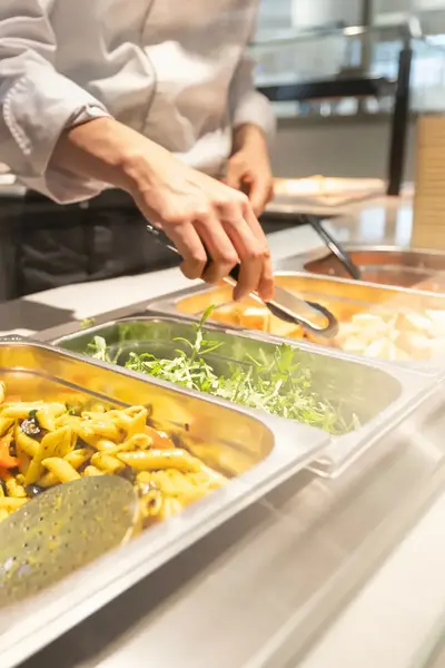 Close-up van buffetbar met onder meer pasta penne
