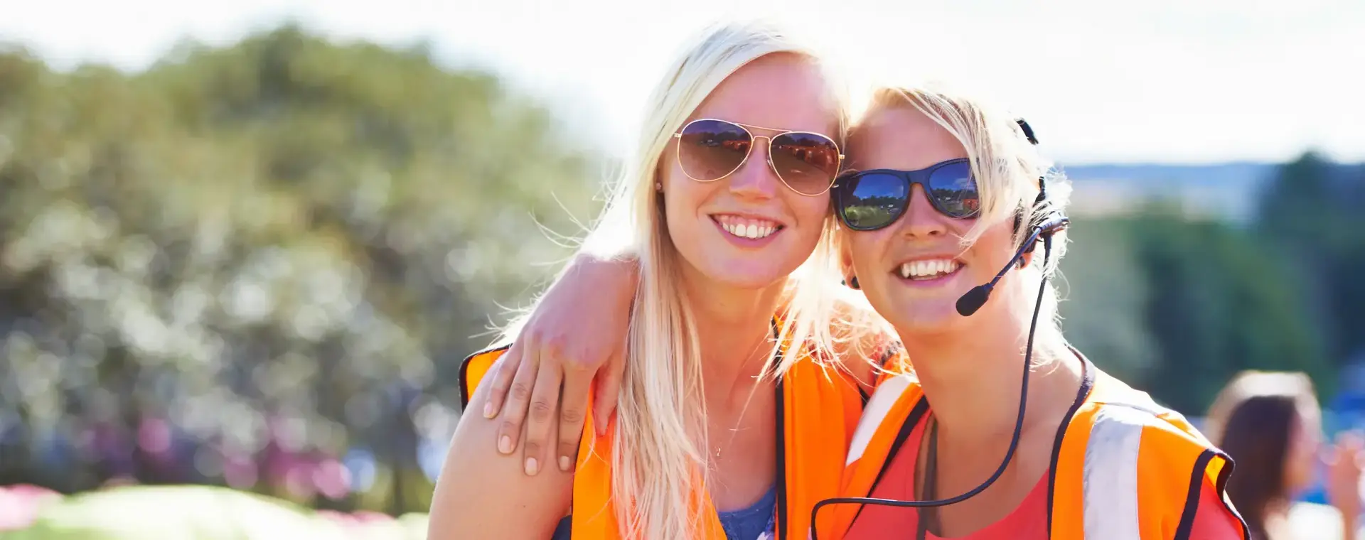 twee meisjes in oranje hesje op evenement