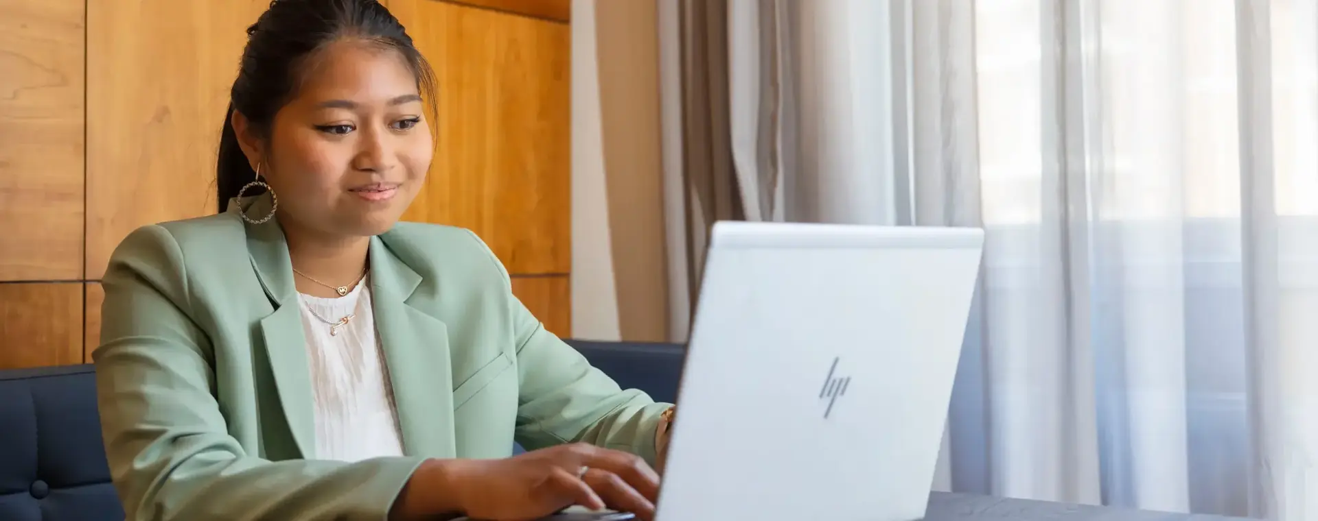 Jonge vrouw achter laptop in rustige ruimte