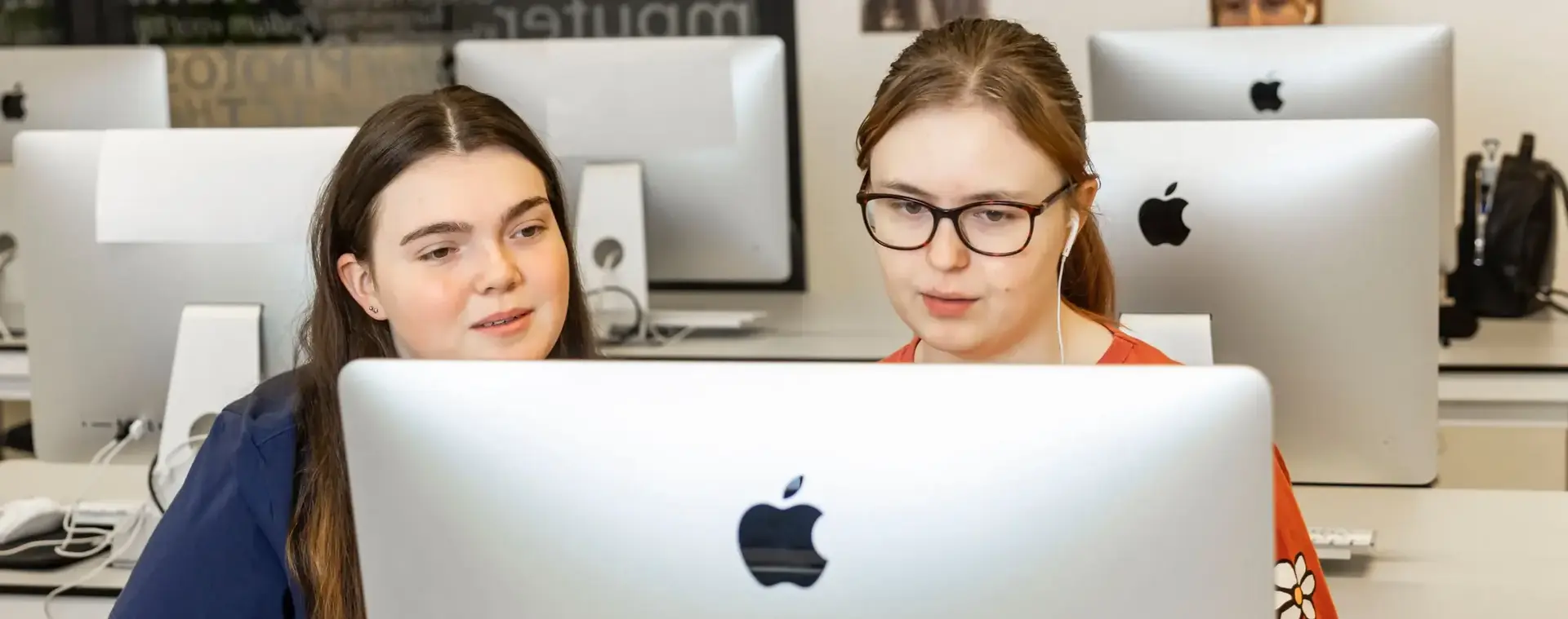 Twee studenten zitten samen achter een Imac te werken