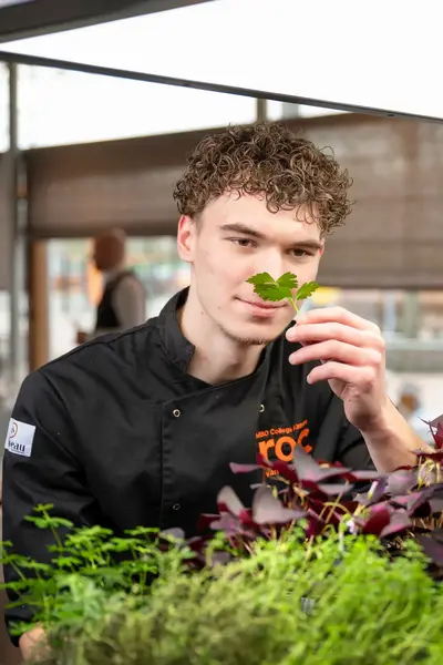 Student in kruidentuin ruikt aan kruiden