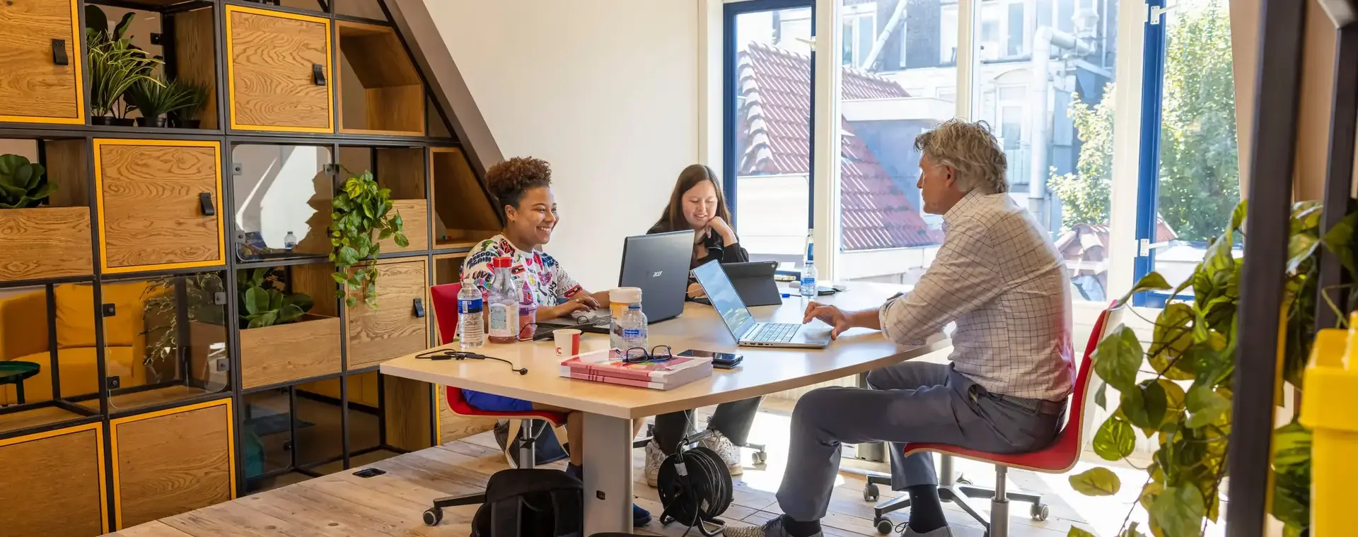 Studenten werken samen in een creatieve ruimte.