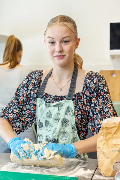 Studenten kneden deeg in keuken