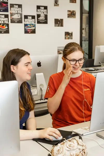 Twee studentes achter een Imac-computer.