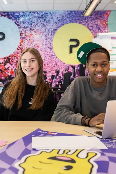 Twee studenten achter bureau met laptop