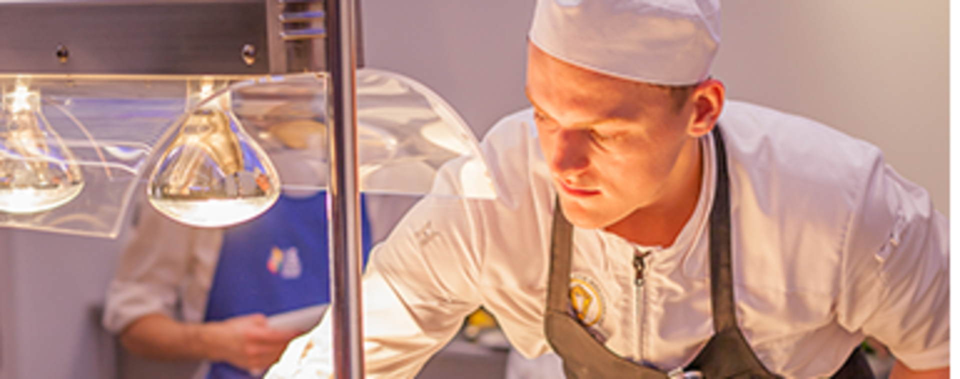 Student in kokskleding oefent basistechnieken in een professionele horecakeuken