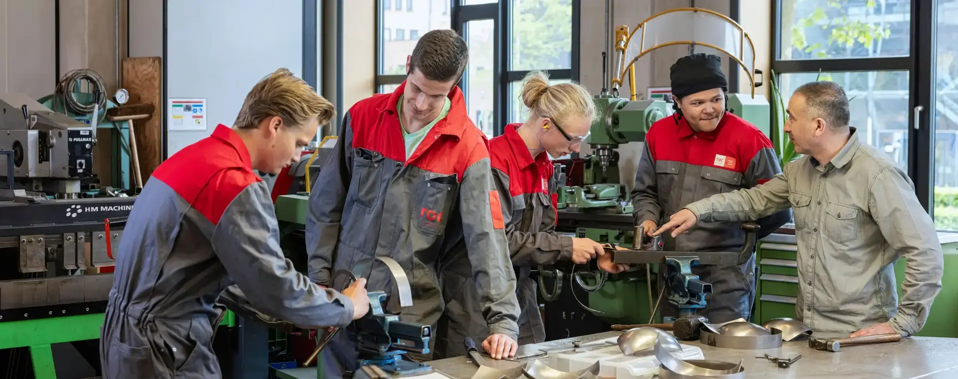 Studenten en docent staan om tafel met technische apparatuur