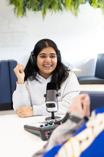 Studente achter een microfoon wordt geïnterviewd.