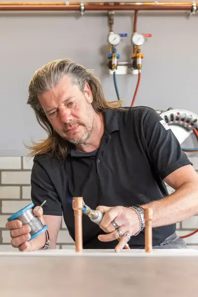 Docent elektrotechniek sleutelt aan elektrotechnische installatie