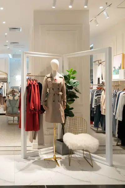 Kledingwinkel met stijlvolle inrichting, mannequins en rekken vol dameskleding.