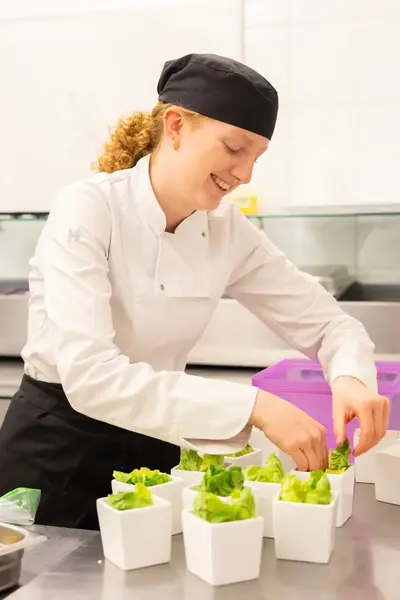 Kok serveert salade in keuken