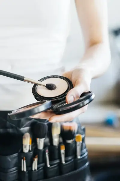 Riem met accessoires voor visagie, waaronder kwastjes