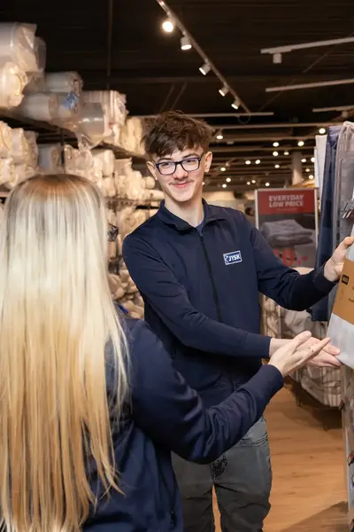 Student helpt een klant met product advies in een winkel