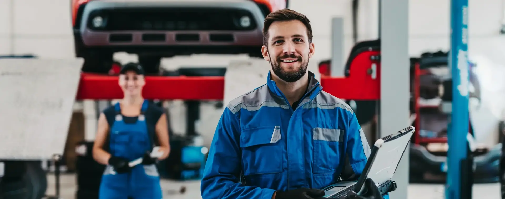 Automonteurs in grote garage met laptop