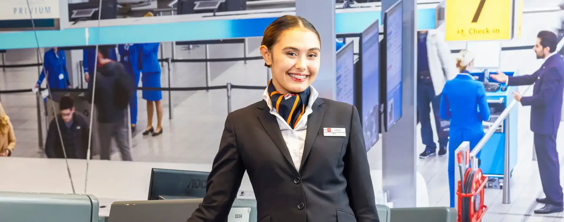 Stewardess met koffer bij incheckbalie