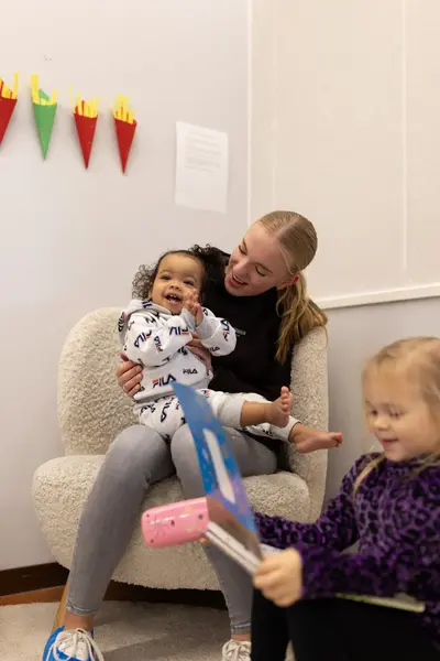 Student in stoel heeft plezier met lachend kind op schoot 