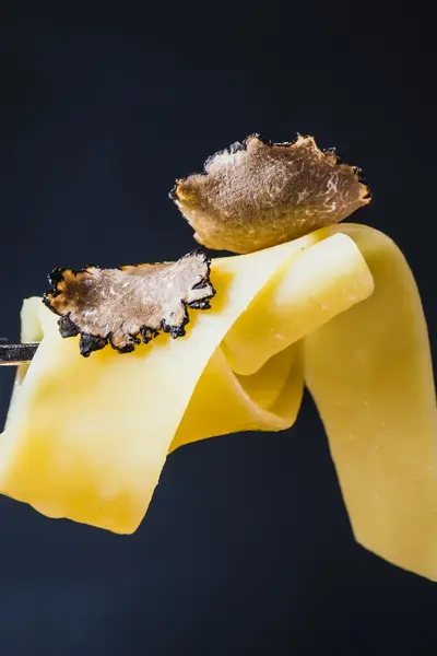 Stukjes truffel op pasta op vork