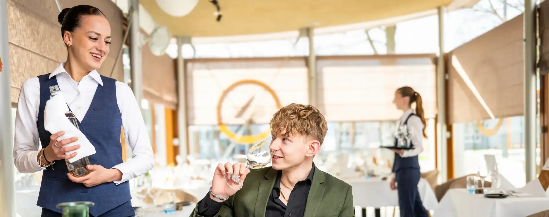 Medewerker bedient gast aan gedekte tafel
