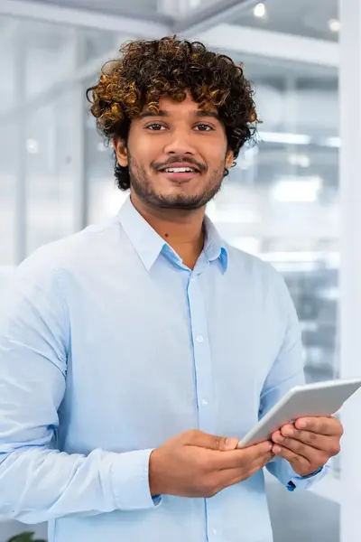 Professional staat klaar met tablet in een moderne kantoorruimte