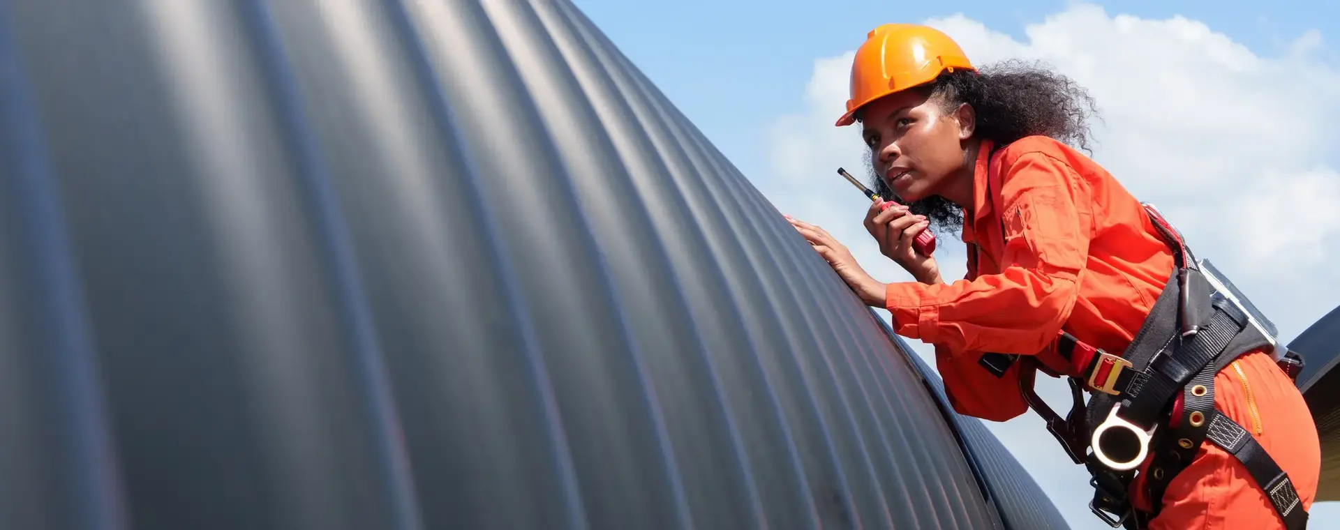 Student onderhoudstechniek op ladder met walkietalkie
