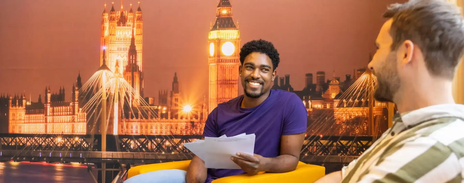 Twee zittende studenten voor een London-achtergrond