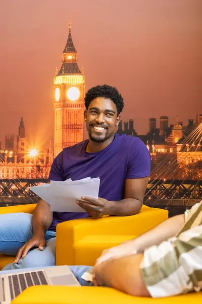Twee zittende studenten voor een London-achtergrond
