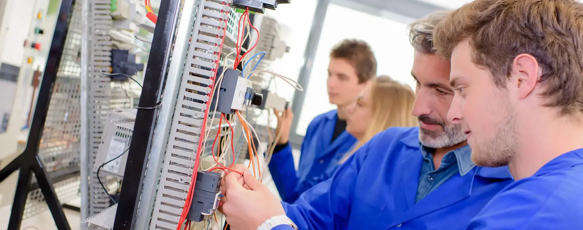 Docent legt aan student iets uit over de elektra in een praktijklokaal